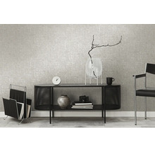 Woonkamer met grijs textielbehang, zwart dressoir, tijdschriftenrek en decoratieve accessoires