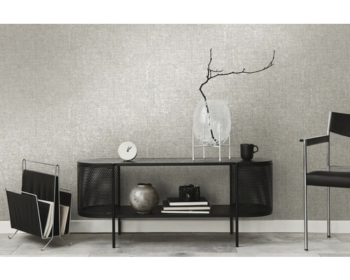 Woonkamer met grijs textielbehang, zwart dressoir, tijdschriftenrek en decoratieve accessoires