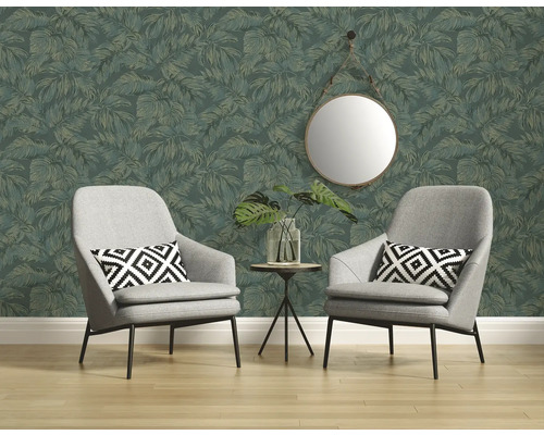 Twee fauteuils voor een wand met bladmotiefbehang, met daarboven een ronde spiegel