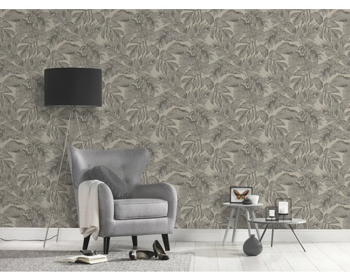 Woonkamer met fauteuil, vloerlamp en behang met bladerpatroon