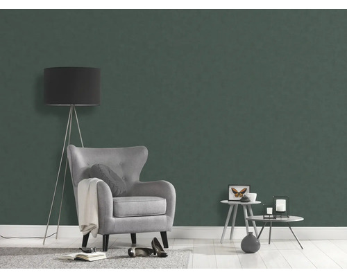 Woonkamer met groene vliesbehang, fauteuil en vloerlamp
