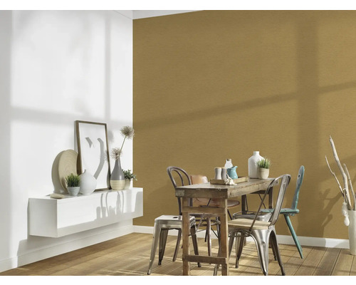 Eetkamer met houten tafel, stoelen en gouden wanddecoratie