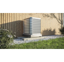 Buitenairconditioner op betonnen sokkel voor een houten wand