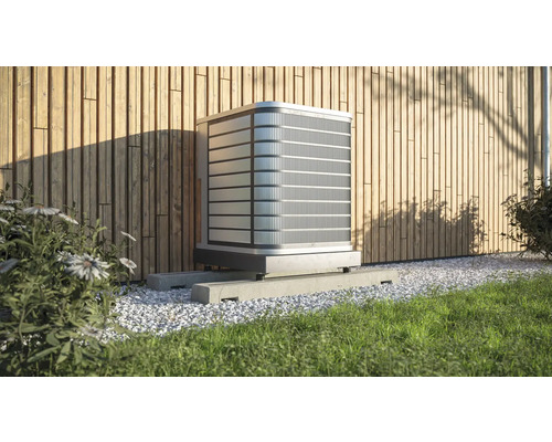 Buitenairconditioner op betonnen sokkel voor een houten wand