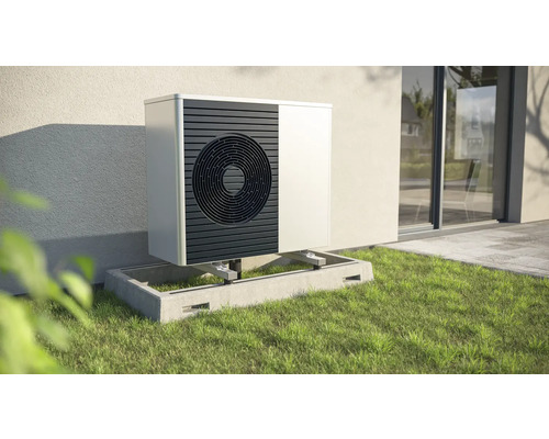 Buitenwarmtepomp op betonnen fundering in de tuin