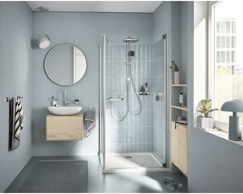 Badkamer met douche, wastafel, spiegel en handdoeken