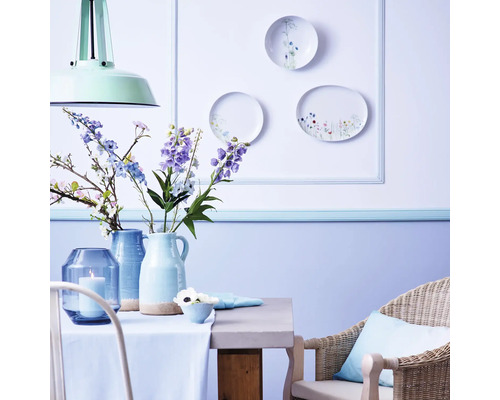 Decoratieve eethoek met tafel, stoel, vazen, bloemen en wandborden