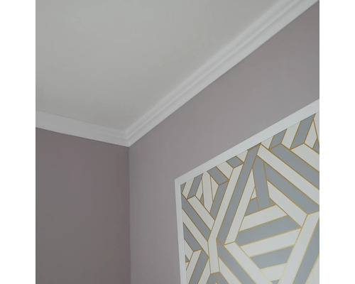 Hoek van een kamer met kroonlijst en wanddecoratie