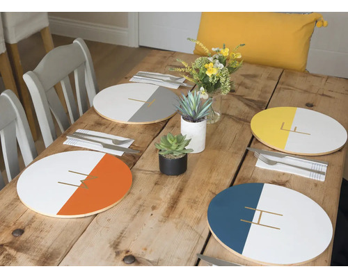 Eettafel met placemats in verschillende kleuren, servies en decoratie