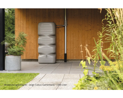 Tuinscene met een grijze 1000 liter Cubus regenton tegen een houten wand
