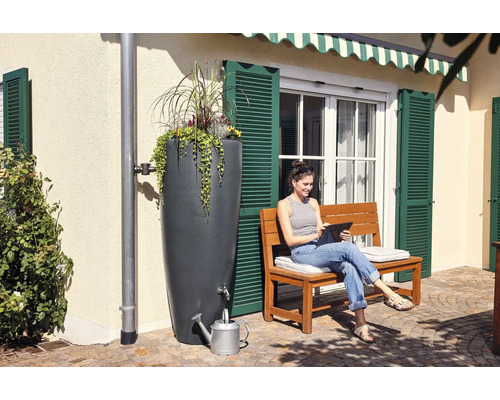 Regenton met beplanting en vrouw met tablet op een bank