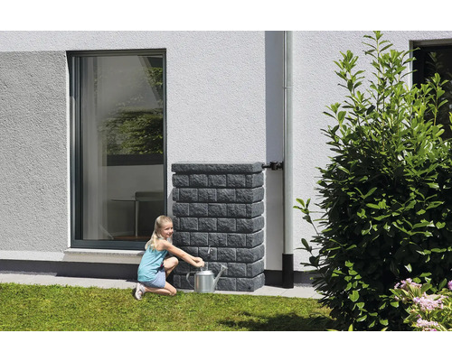 Meisje vult gieter bij regenwatertank