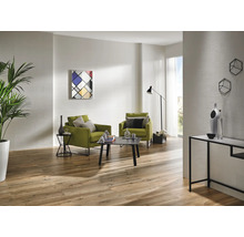Lichte woonkamer met houten vloer, twee groene fauteuils, salontafel en moderne decoratie