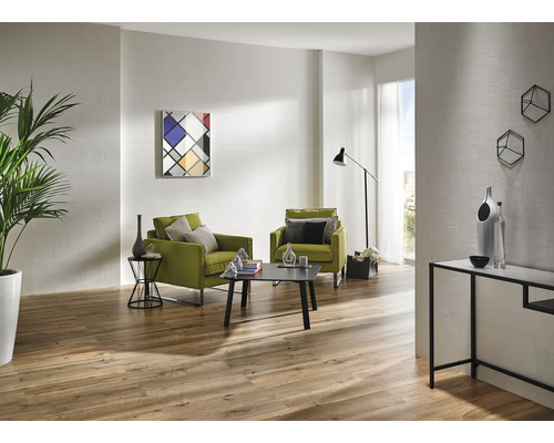 Lichte woonkamer met houten vloer, twee groene fauteuils, salontafel en moderne decoratie