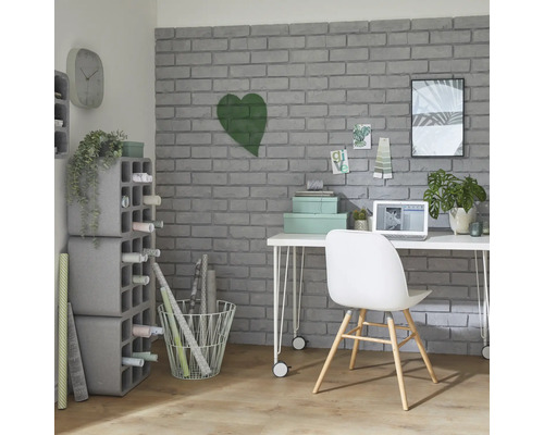 Werkkamer met bureau, stoel, rekken en decoratieartikelen voor een grijze bakstenen muur