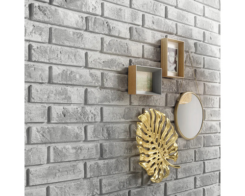 Muurdecoratie met steenlook en decoratieve elementen zoals fotolijsten, spiegel en blad ornament