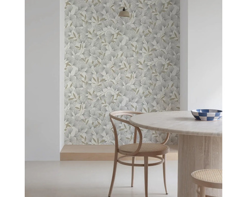 Kamerweergave met een patroonbehang met bladeren, een ronde tafel en een houten stoel