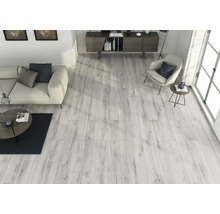 Lichte woonkamer met houten vloer, bank, fauteuil en dressoir