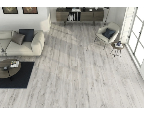 Lichte woonkamer met houten vloer, bank, fauteuil en dressoir