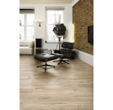 Lichte woonkamer met houten vloer, fauteuil en staande lamp