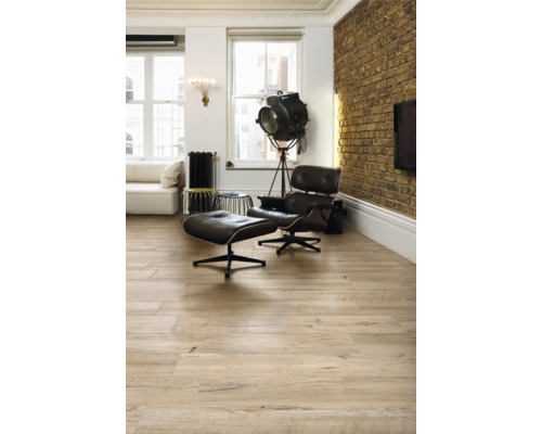 Lichte woonkamer met houten vloer, fauteuil en staande lamp