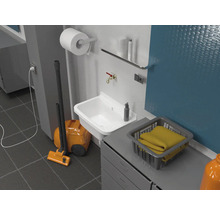 Wasruimte met wastafel, stofzuiger, wasmand en diverse schoonmaakartikelen