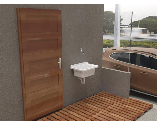 Buitenruimte met houten vloer, deur en wastafel.