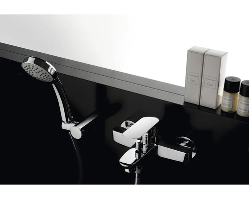 Kraan met handdouche en verzorgingsproducten in de badkamer