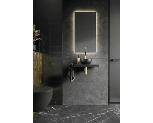 Moderne badkamer met verlichte spiegel, opzetwastafel, kraan, handdoek en toilet