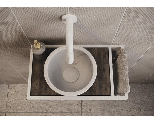 Bovenaanzicht van een badkamerwastafel met kraan, zeepdispenser en handdoek