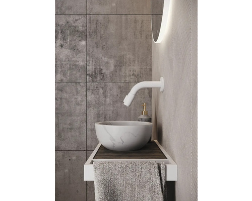 Badkamer wastafel met kraan, handdoek en verlichte spiegel