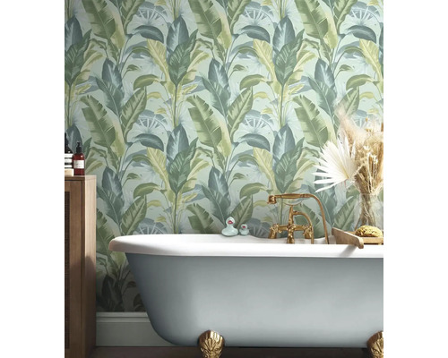 Badkamer met bad en junglebehang met plantmotieven.