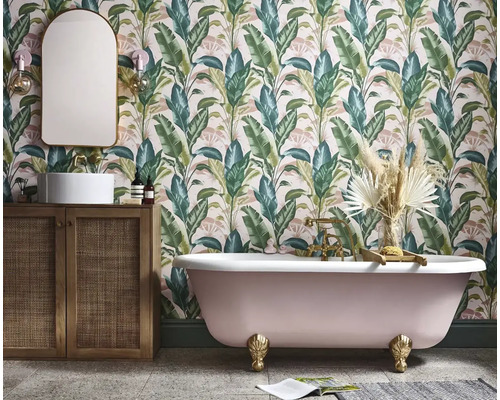 Badkamer met bad, wastafel en behang met plantenmotief
