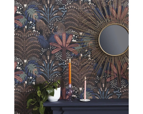 Detailopname van een kamer met een gedessineerd junglebehang, versierd met luipaarden en bomen, samen met een spiegel en decoraties op een schoorsteenmantel.