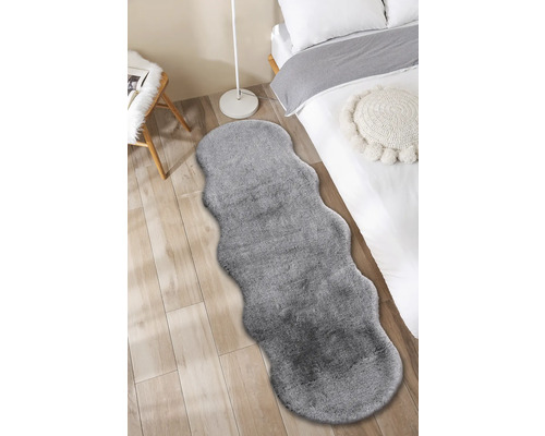 Grijs tapijt in een slaapkamer met bed