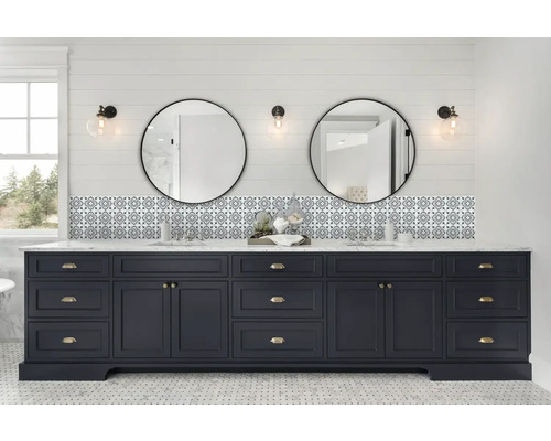 Badkamer met blauw wastafelonderstel, twee ronde spiegels en betegelde achterwand