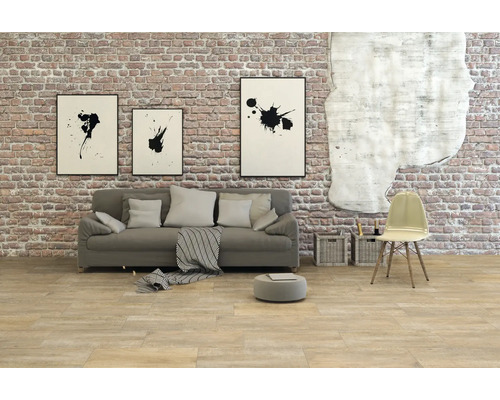 Woonkamer met bank, stoel en wanddecoratie voor een bakstenen muur