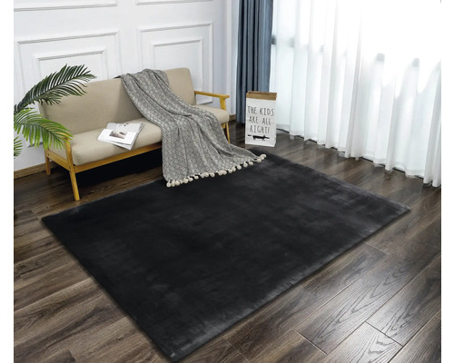 Interieurscène met een zwart vloerkleed, bank en gordijnen