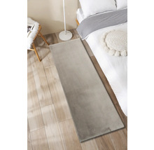 Slaapkamer met vloerkleed, bed, lamp en stoel