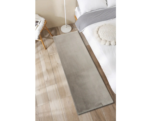 Slaapkamer met vloerkleed, bed, lamp en stoel