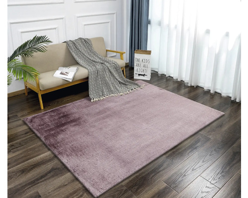 Woonkamer met bank en gemêleerd tapijt