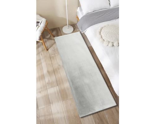 Tapijt in slaapkamer met bed, stoel en vloerlamp