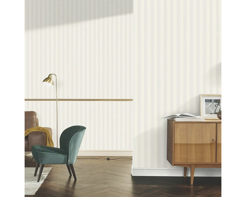 Woonkamer met gestreept behang, fauteuil en dressoir