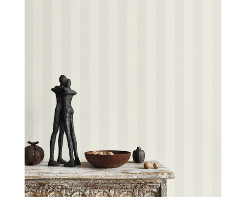 Foto van een decoratie op een tafel met gestreept behang op de achtergrond.