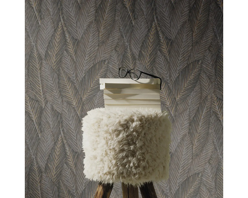 Decoratief behang met bladmotief achter een kruk met stapel boeken en bril