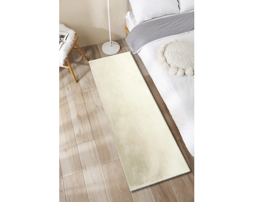 Hoogpolig tapijt in de slaapkamer naast het bed