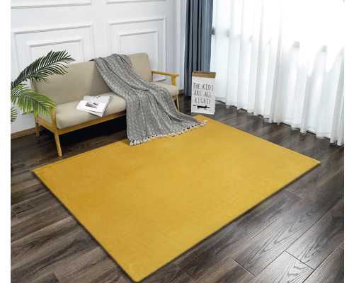 Geel tapijt in een woonkamer met bank en decoratie