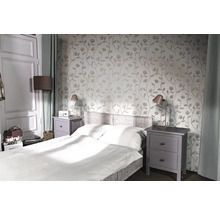 Slaapkamer met bed, nachtkastjes en bloemenbehang