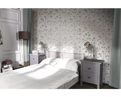 Slaapkamer met bed, nachtkastjes en bloemenbehang