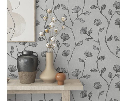 Wanddecoratie met bloemenbehang en decoratieve vazen op een tafel.